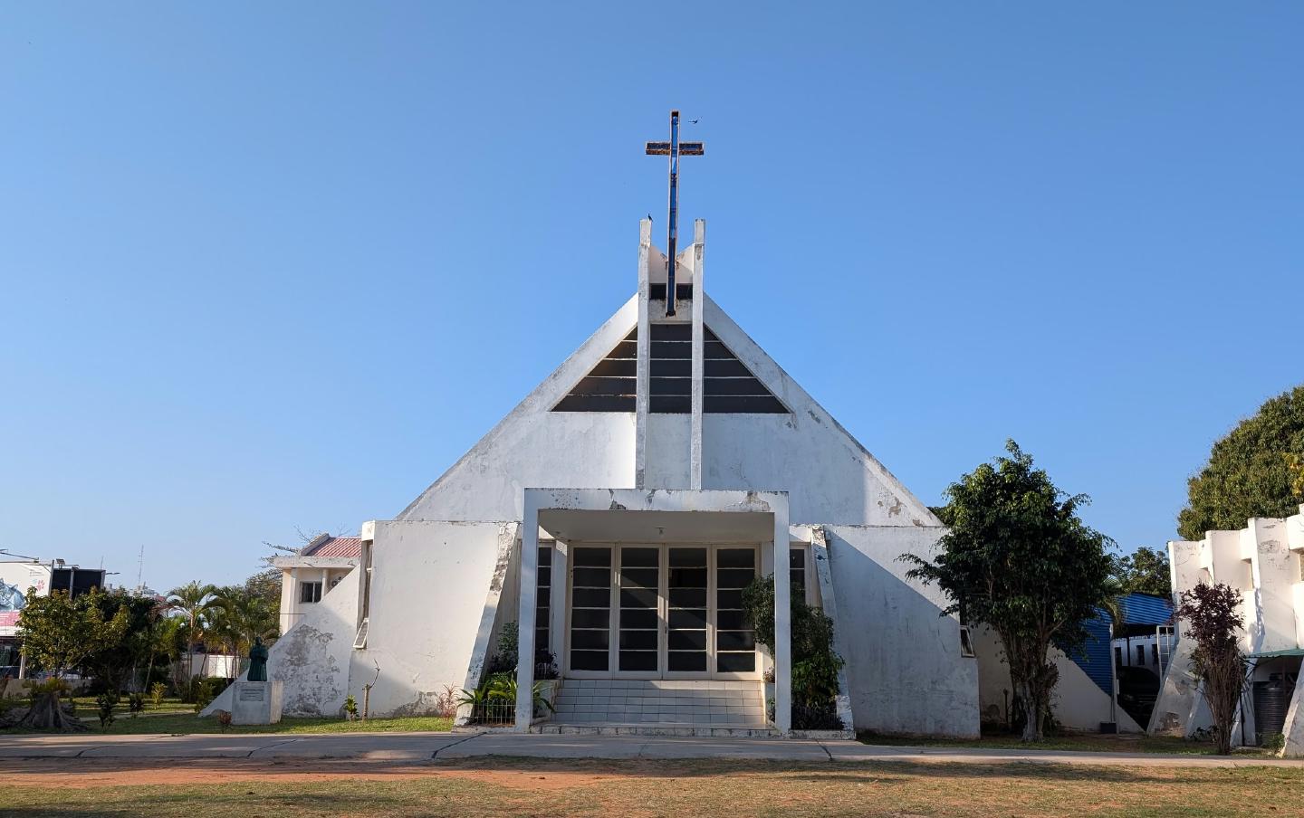 A Capela Martim Lutero: um edifício branco em forma de triângulo, com uma cruz no topo, atrás de um relvado.